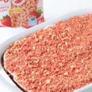 strawberry crunch cake in a white cake pan next to a box of strawberry shortcake ice cream bars.