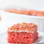 slice of strawberry crunch cake on a white plate.