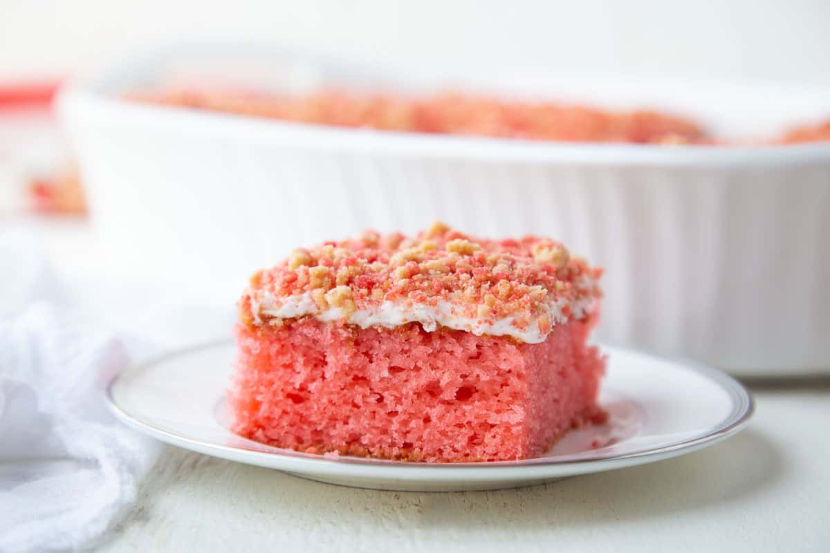 slice of strawberry crunch cake on a white plate.