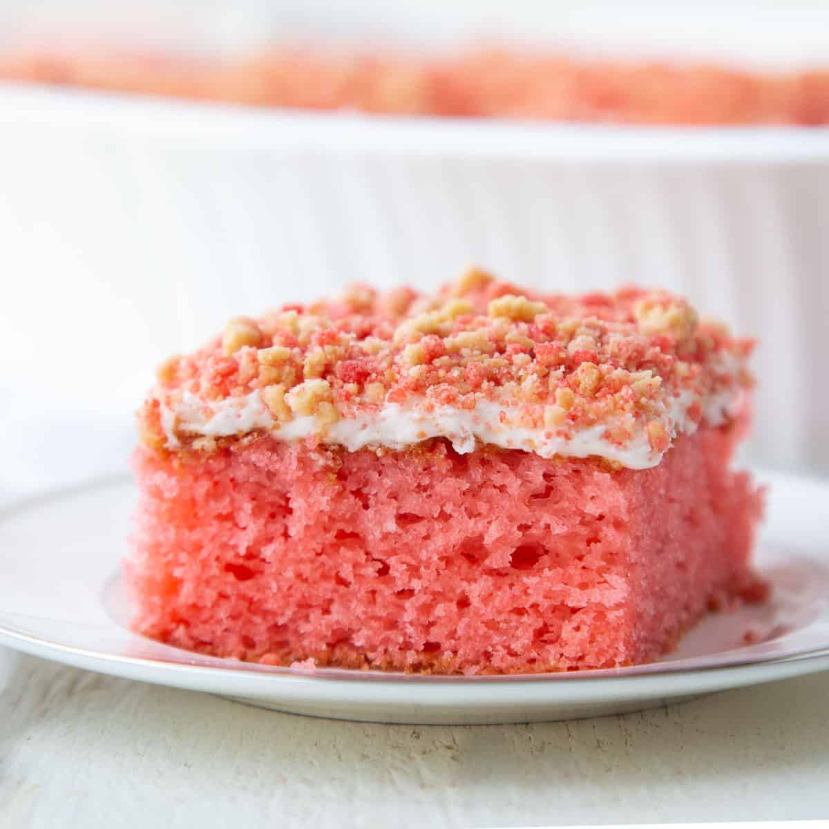 slice of strawberry crunch cake on a white plate.