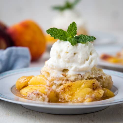 peach cobbler topped with ice cream and a mint sprig.