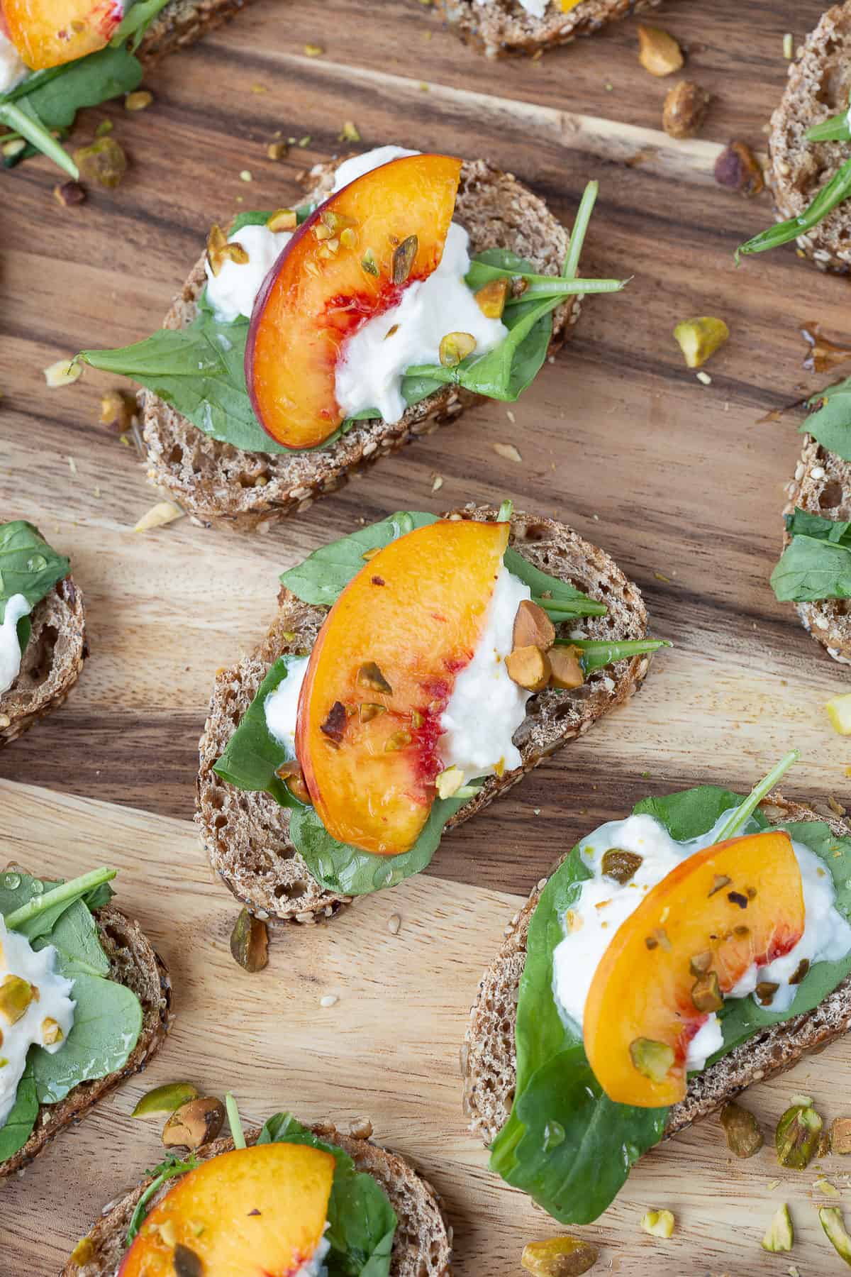 burrata appetizers topped with peaches and pistachios.