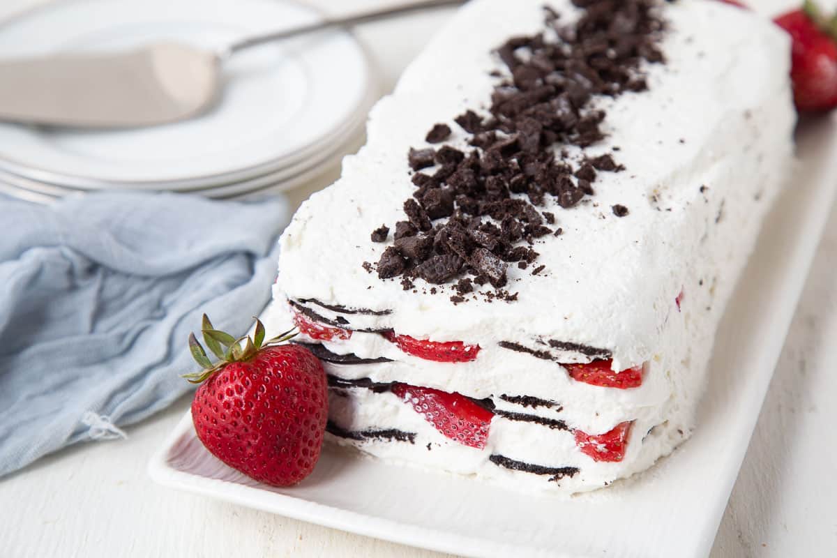 icebox cake with strawberries on a white platter.