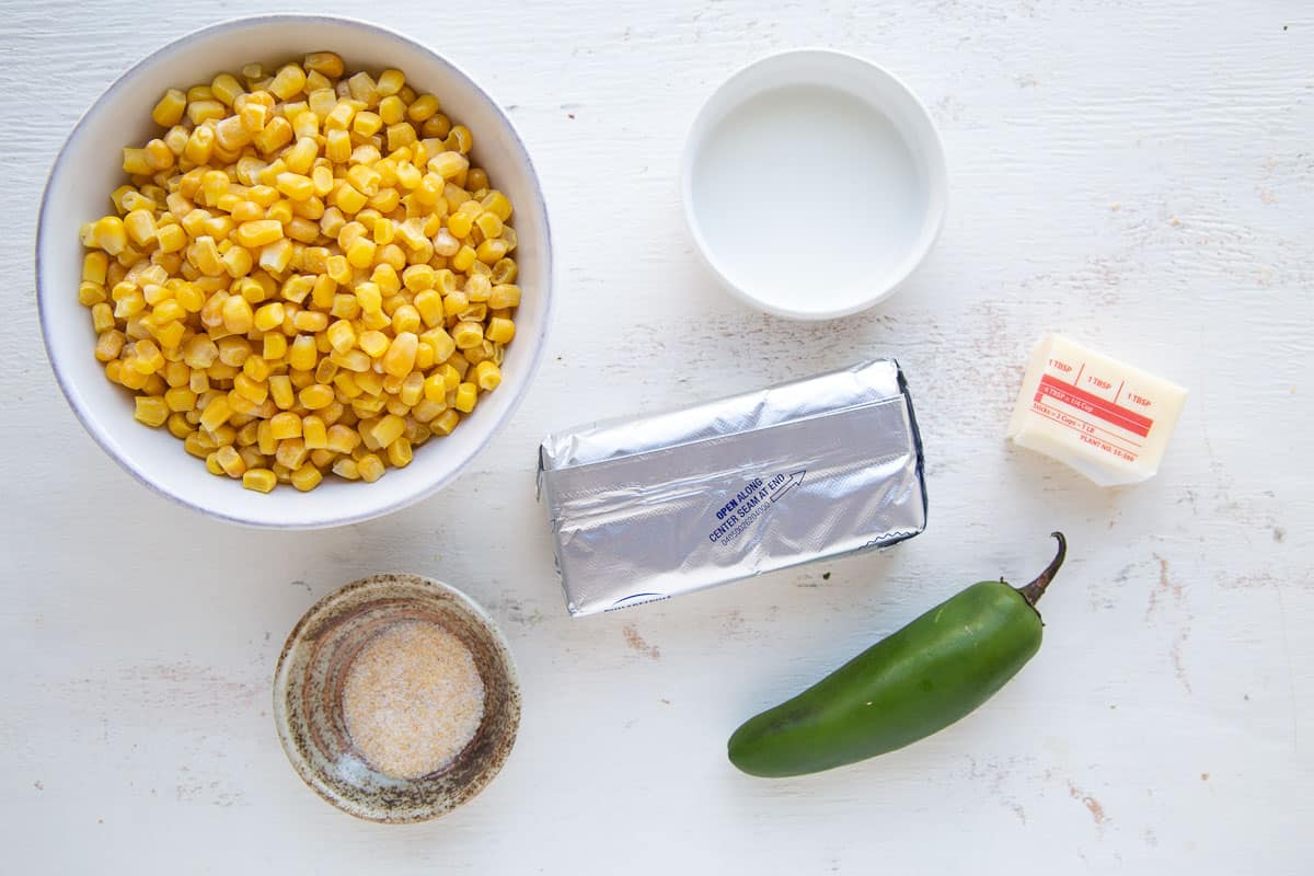 corn, cream cheese, jalapeño, and other ingredients on a white table.