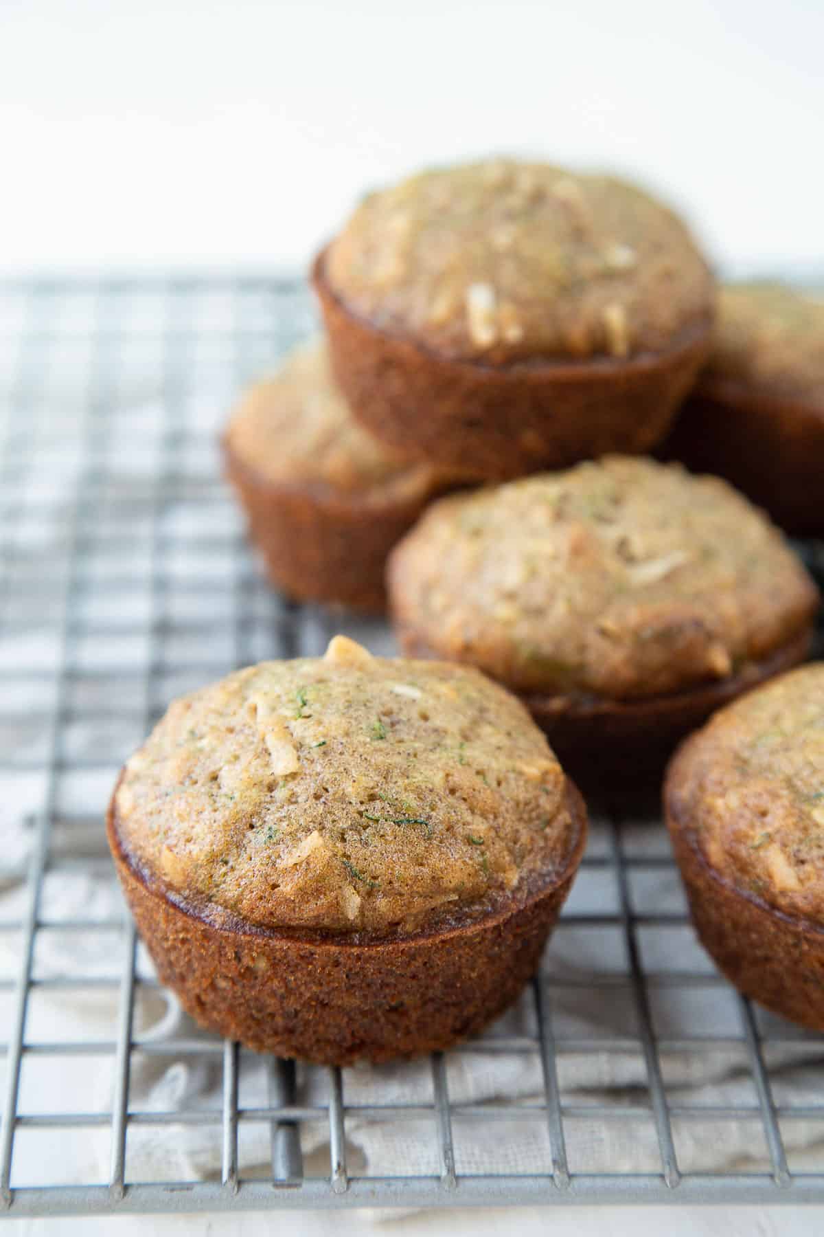 zucchini muffins with walnuts and coconut on a wire rack.