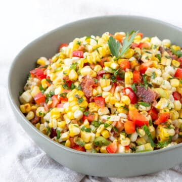 grilled corn salad with bacon in a green bowl.