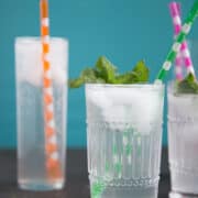 homemade ginger ale in tall glasses with colorful straws and fresh mint garnish.