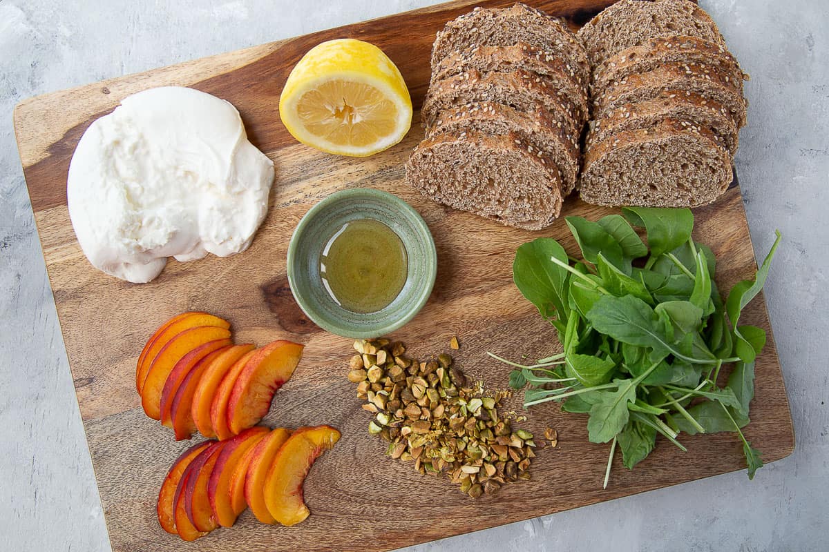 ingredients for burrata appetizers on a wooden board.