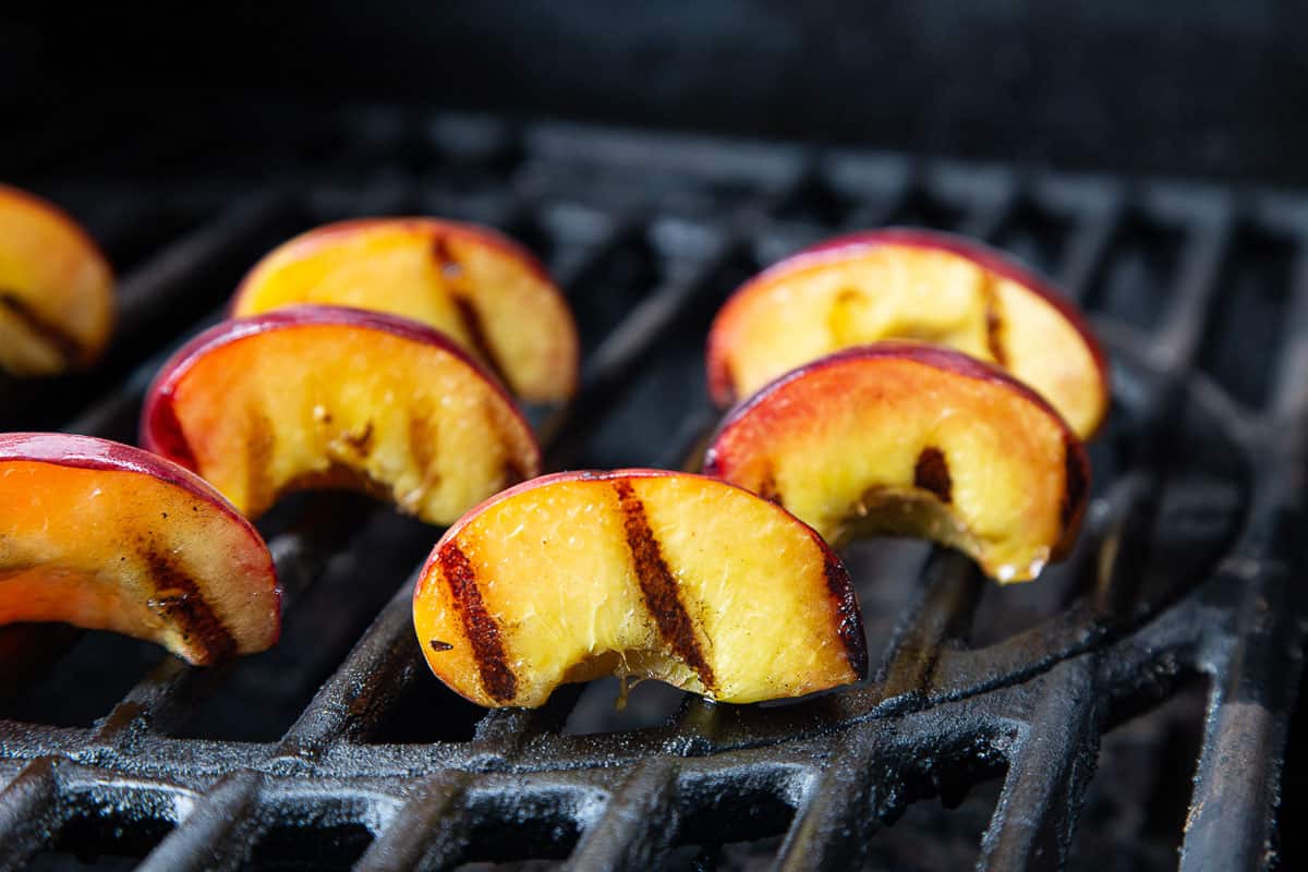 peaches with grill marks on a grill.