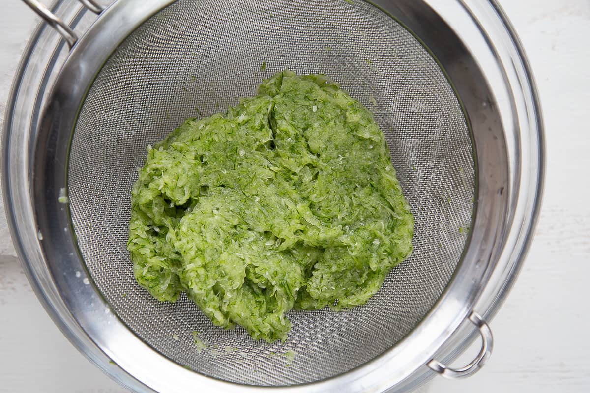 shredded zucchini in a mesh colander.