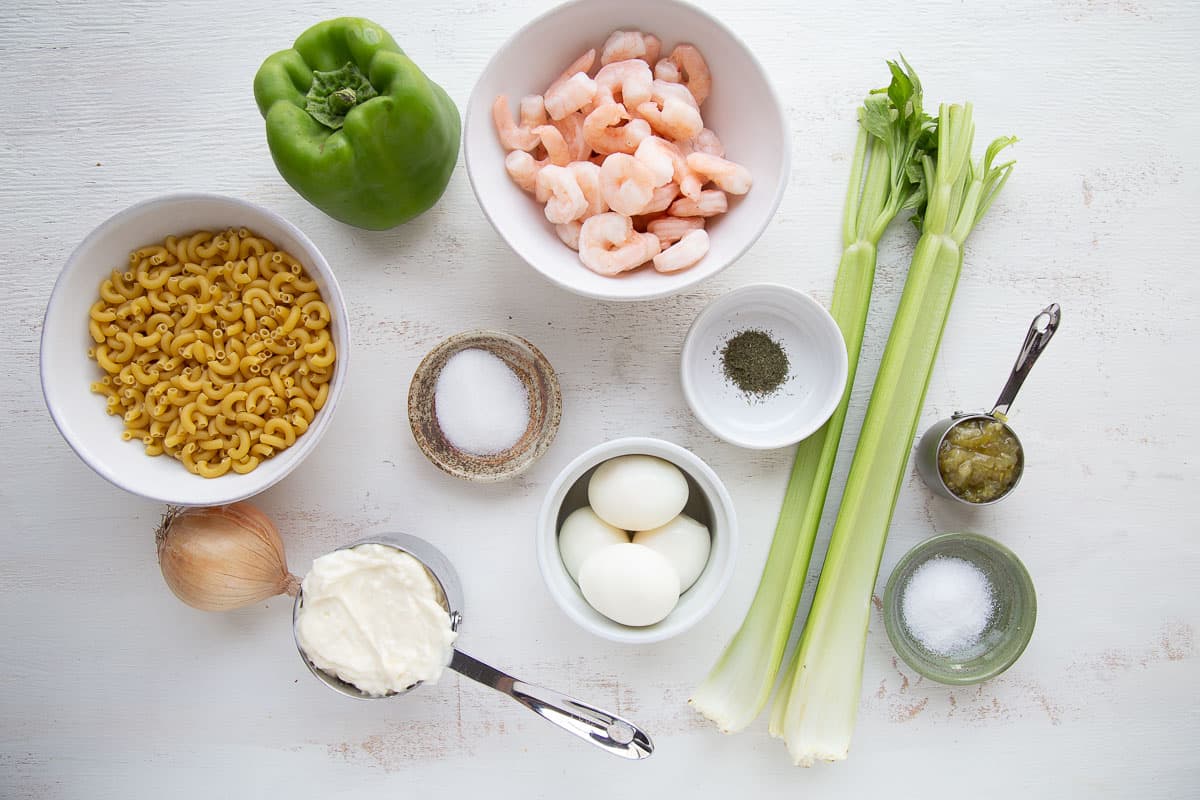 ingredients for pasta salad on a white table.