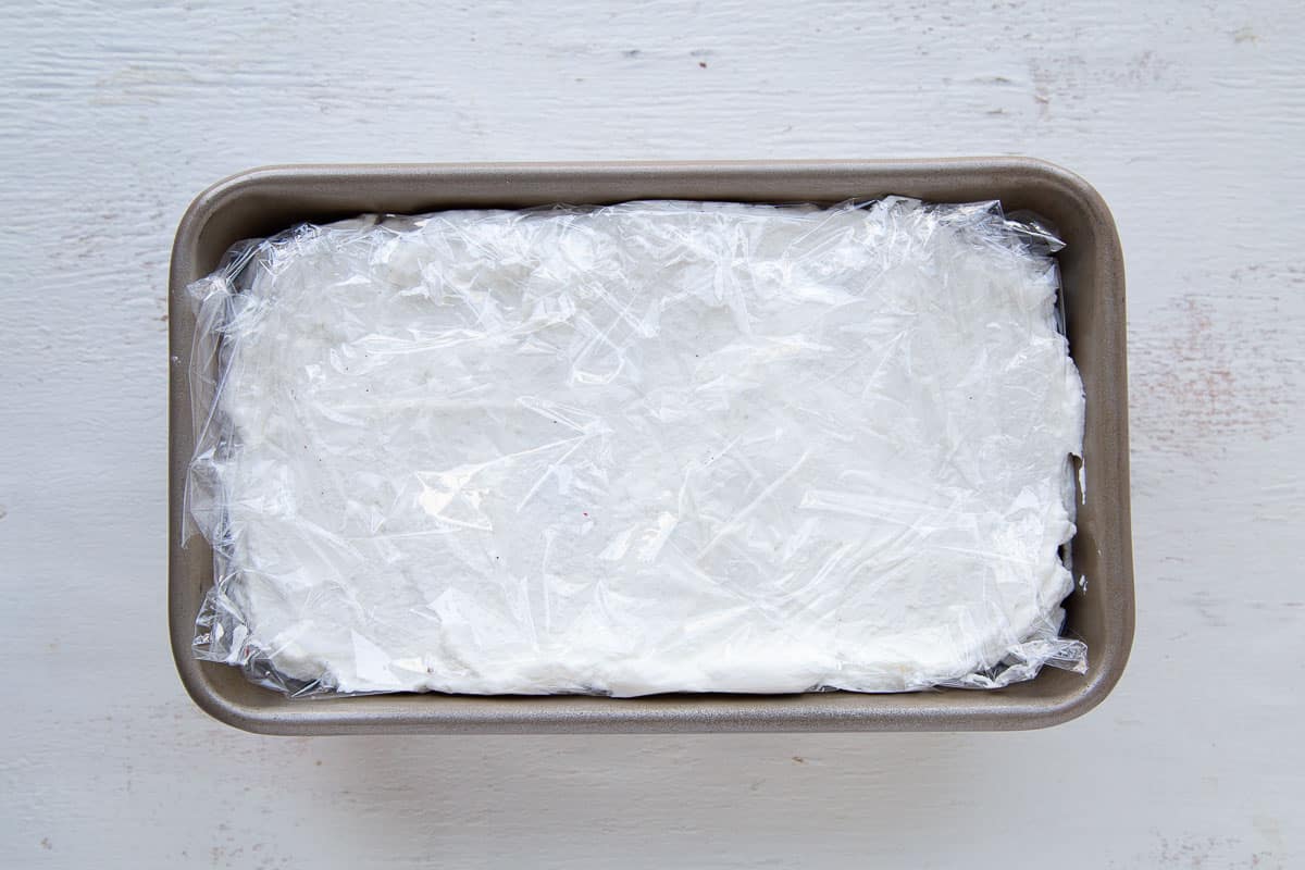 whipped cream in a loaf pan, covered with plastic wrap.