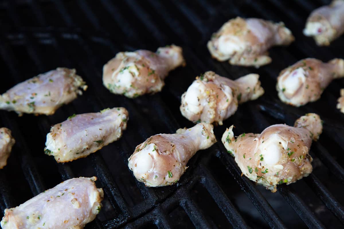 raw chicken wings on the grill.