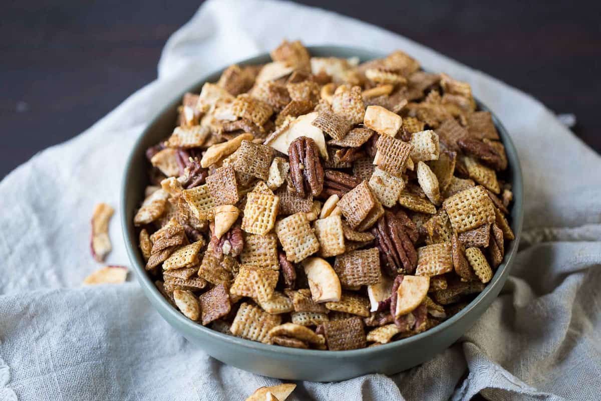 green bowl filled with apple chex mix with pecans.