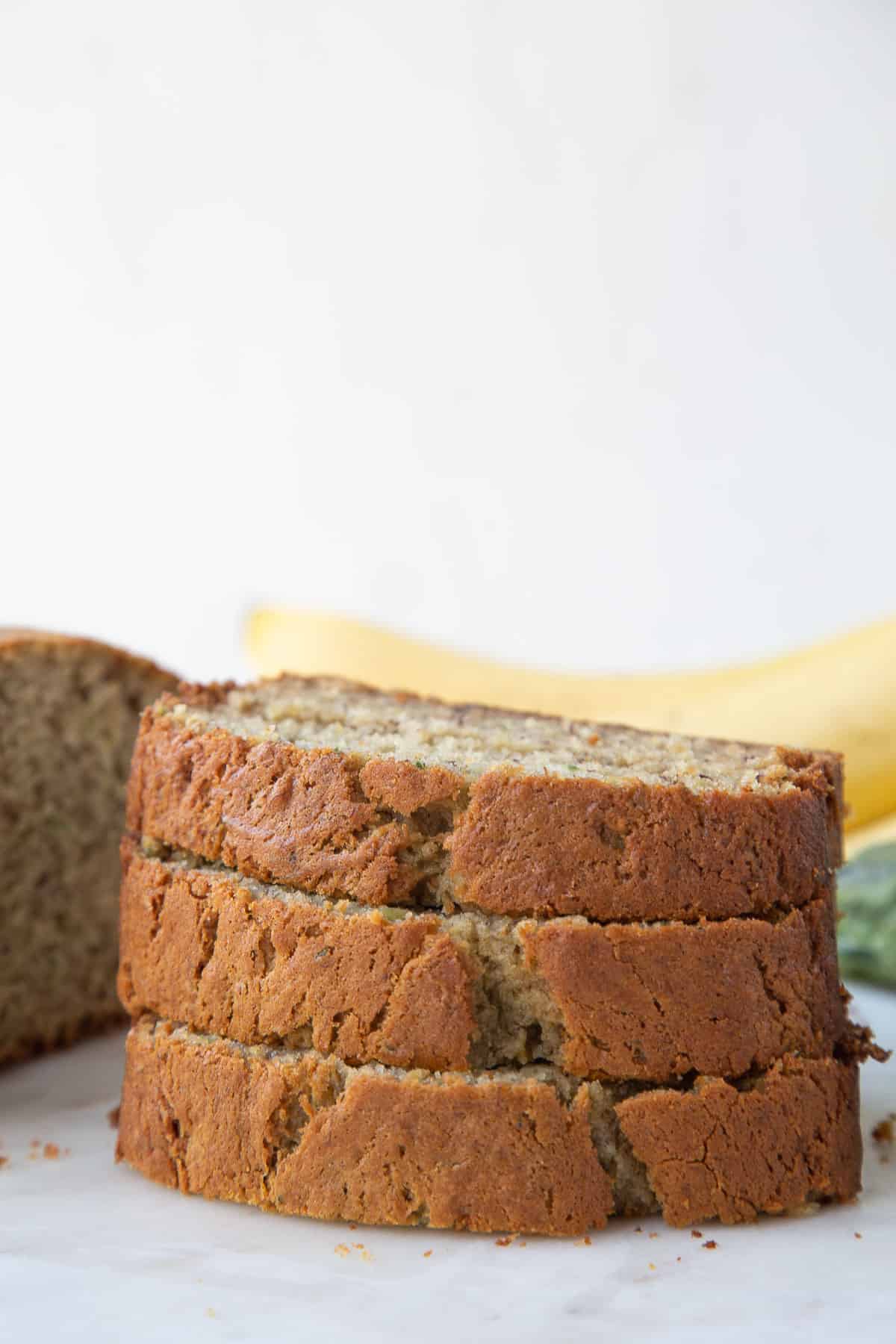 three slices of zucchini banana bread stacked on top of each other.