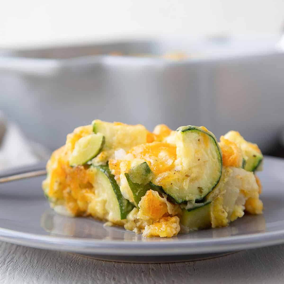 slice of old fashioned zucchini casserole on a gray plate.