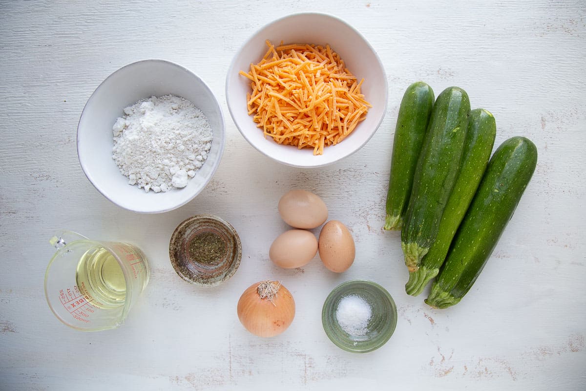 zucchini casserole ingredients on a white table.