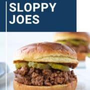 sloppy joe sandwich with pickles on a brioche bun.