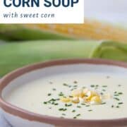 cream of corn soup in a low bowl, topped with chives and corn kernels.