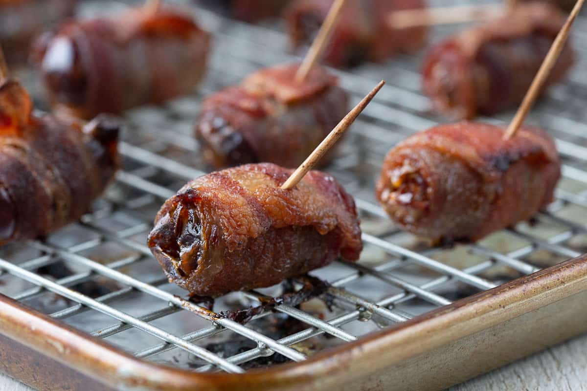 crispy bacon wrapped dates on a wire rack.