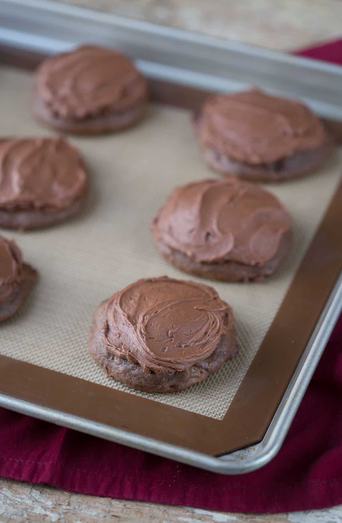cocoa drop cookies on a silicone baking mat on a sheet pan.