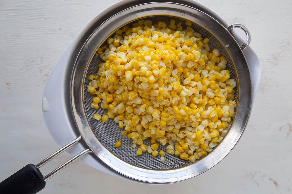 corn kernels in a mesh colander.