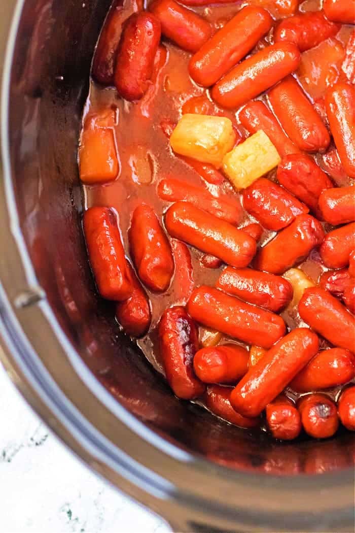 little smokies and chunks of pineapple in a crockpot.