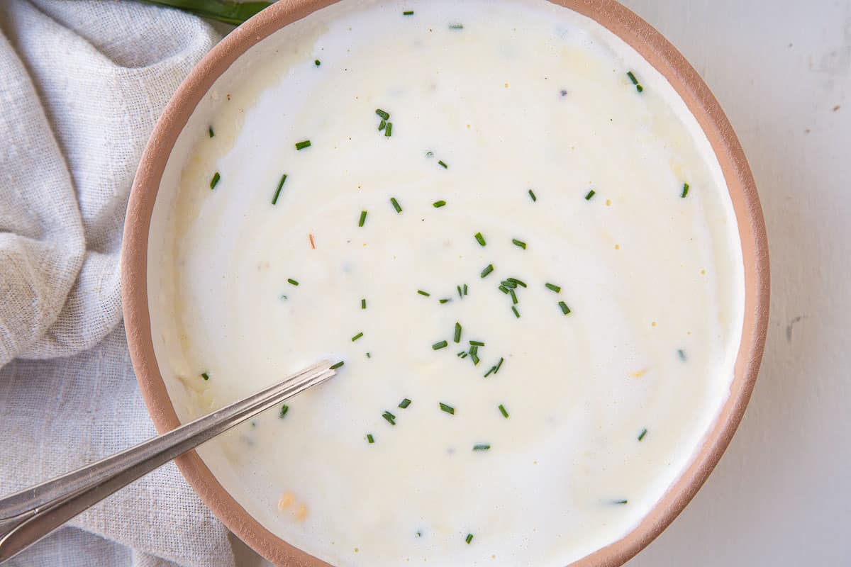 cream of corn soup with a swirl of cream, topped with chives.