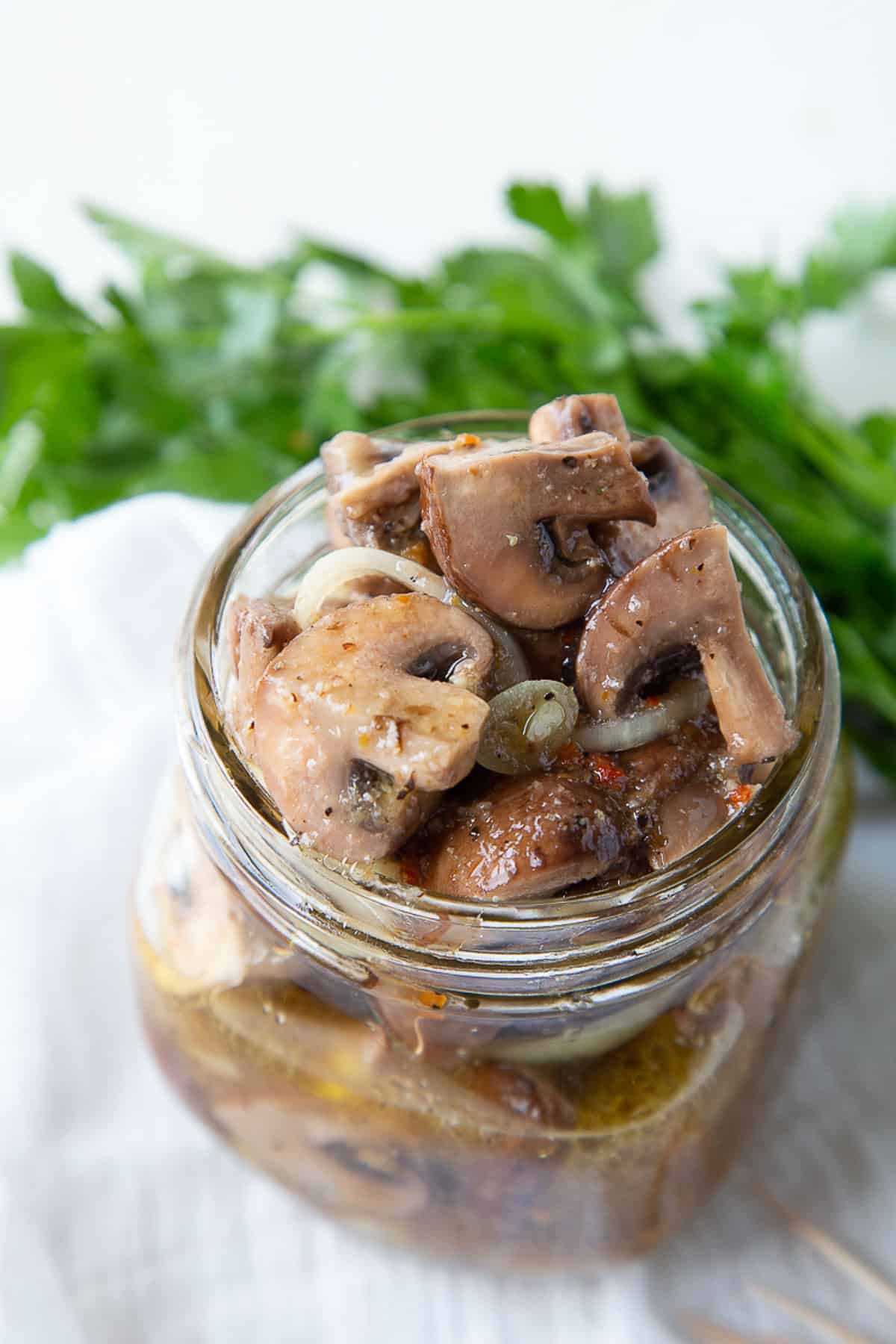 italian marinated mushrooms in a glass mason jar.