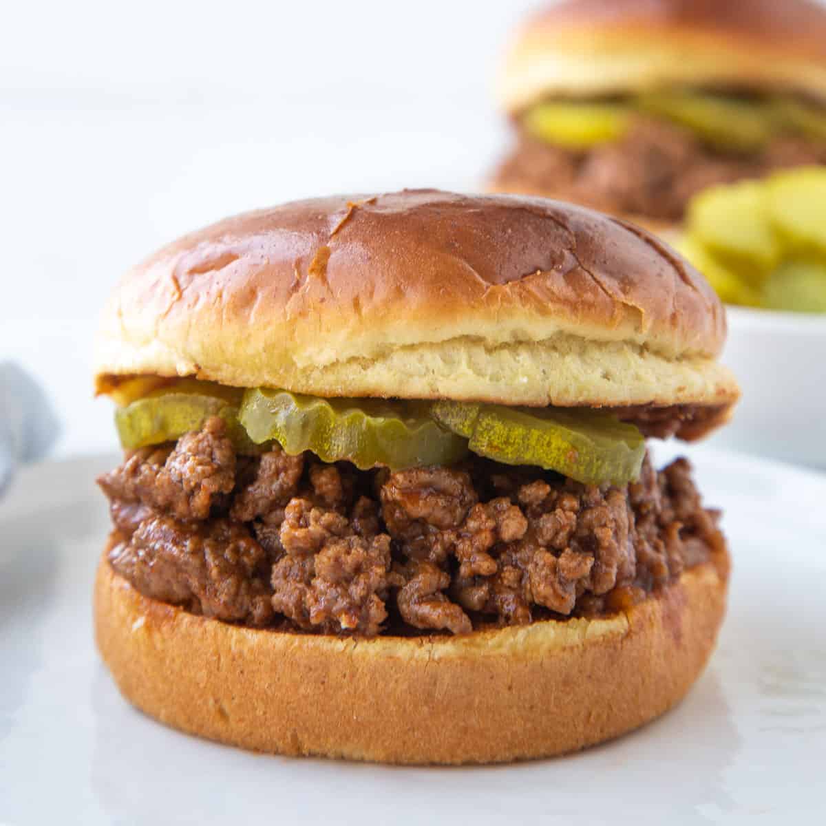 old fashioned sloppy joes meat on a brioche bun with pickles.