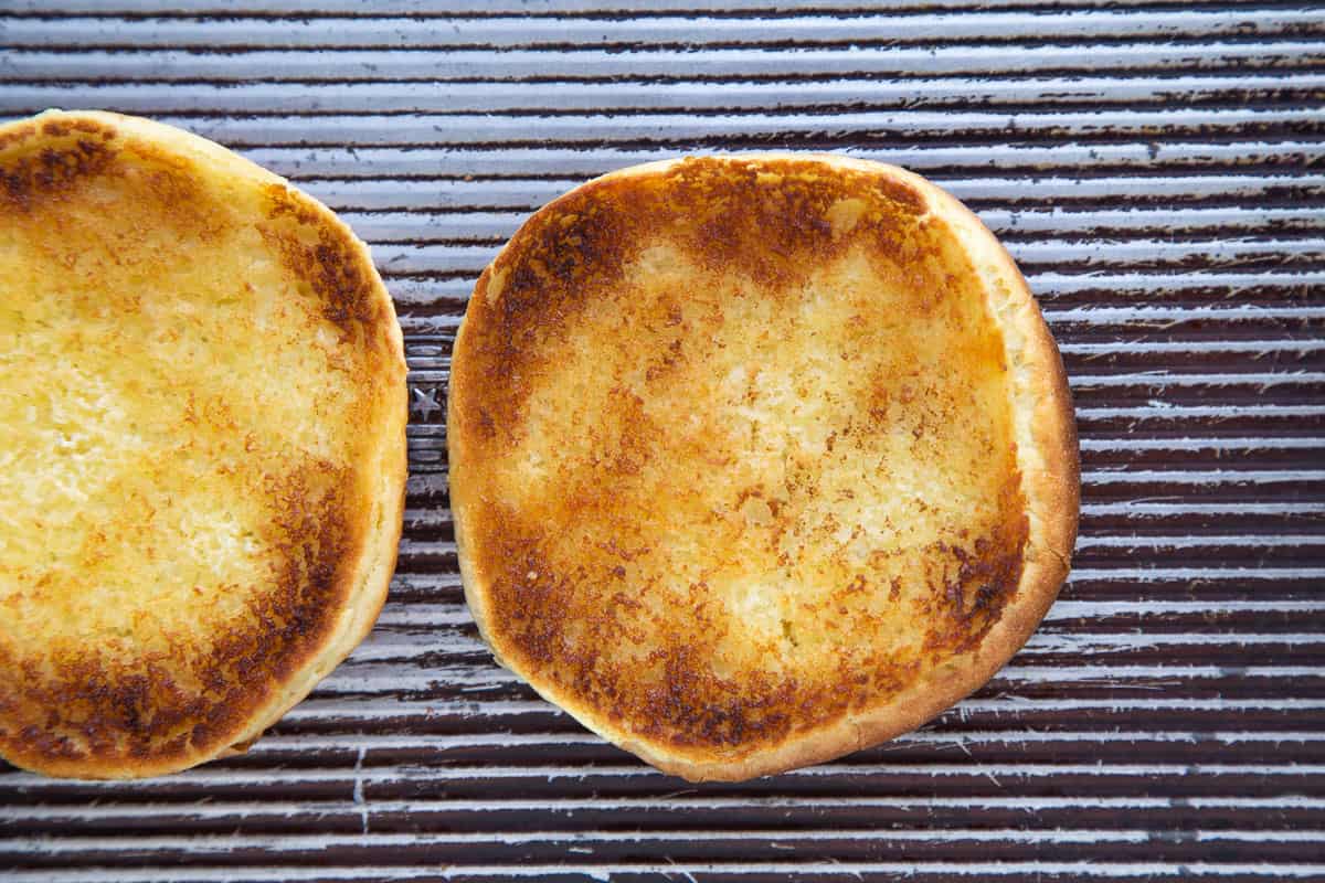 toasted brioche burger buns on a sheet pan.