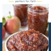 apple butter in a shallow yellow dish next to jars of apple butter.