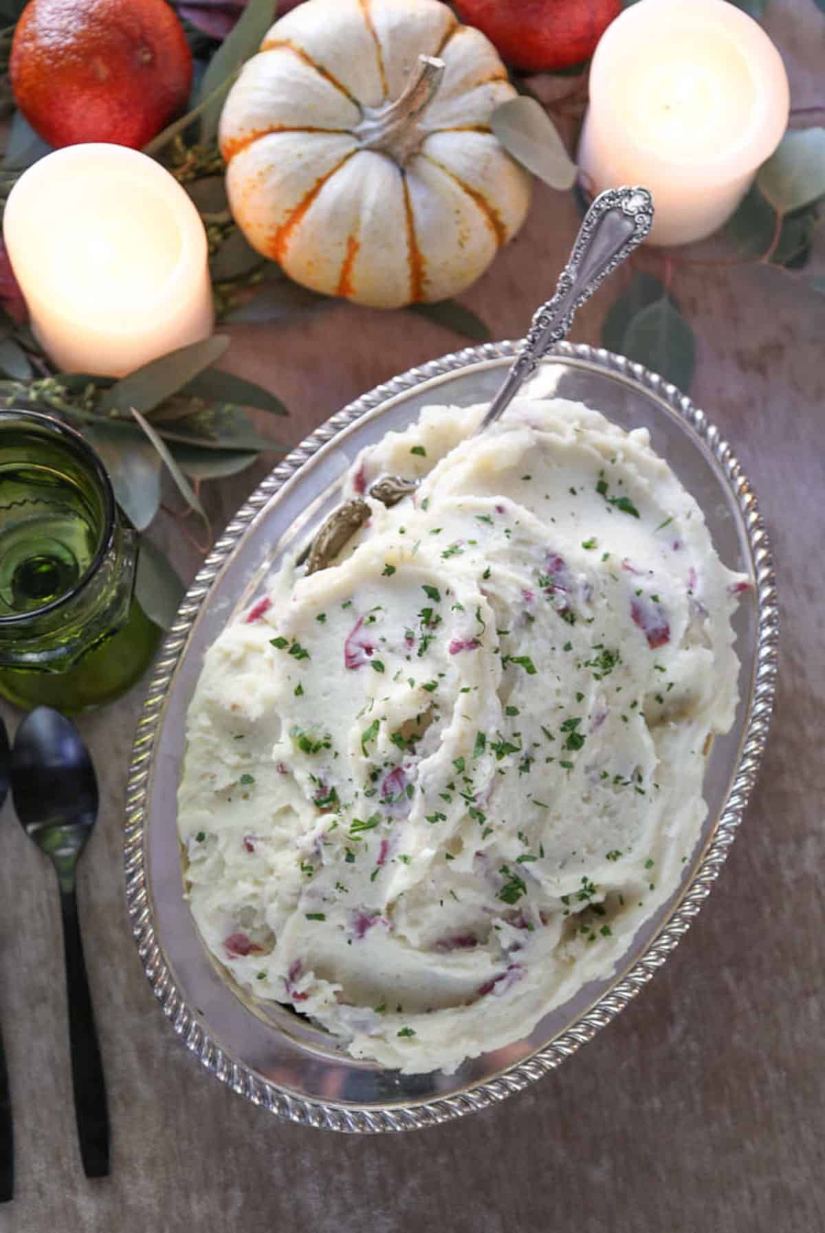 buttermilk mashed potatoes with skins on in an oval metal serving dish.