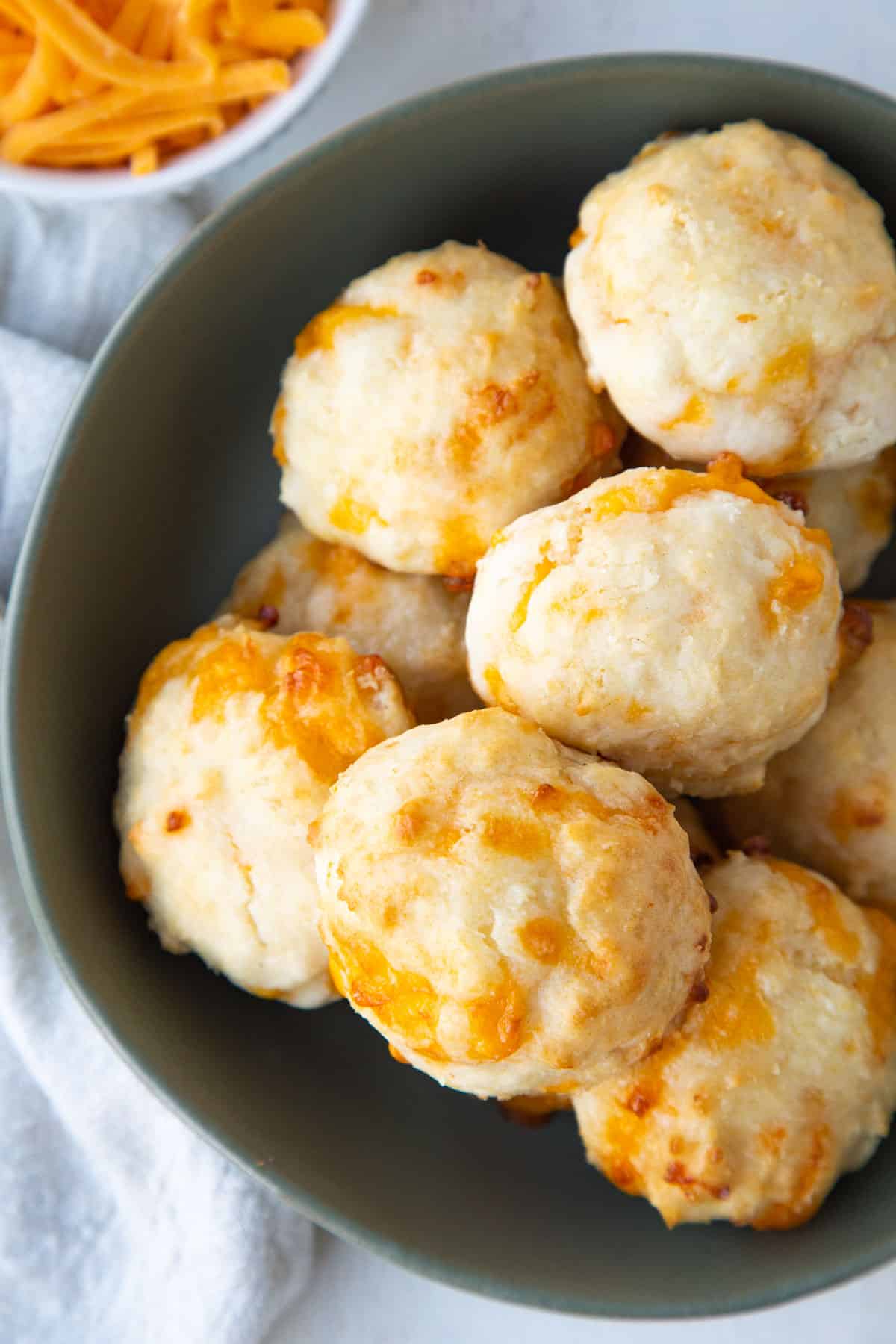 round biscuits with cheddar in a low green bowl.