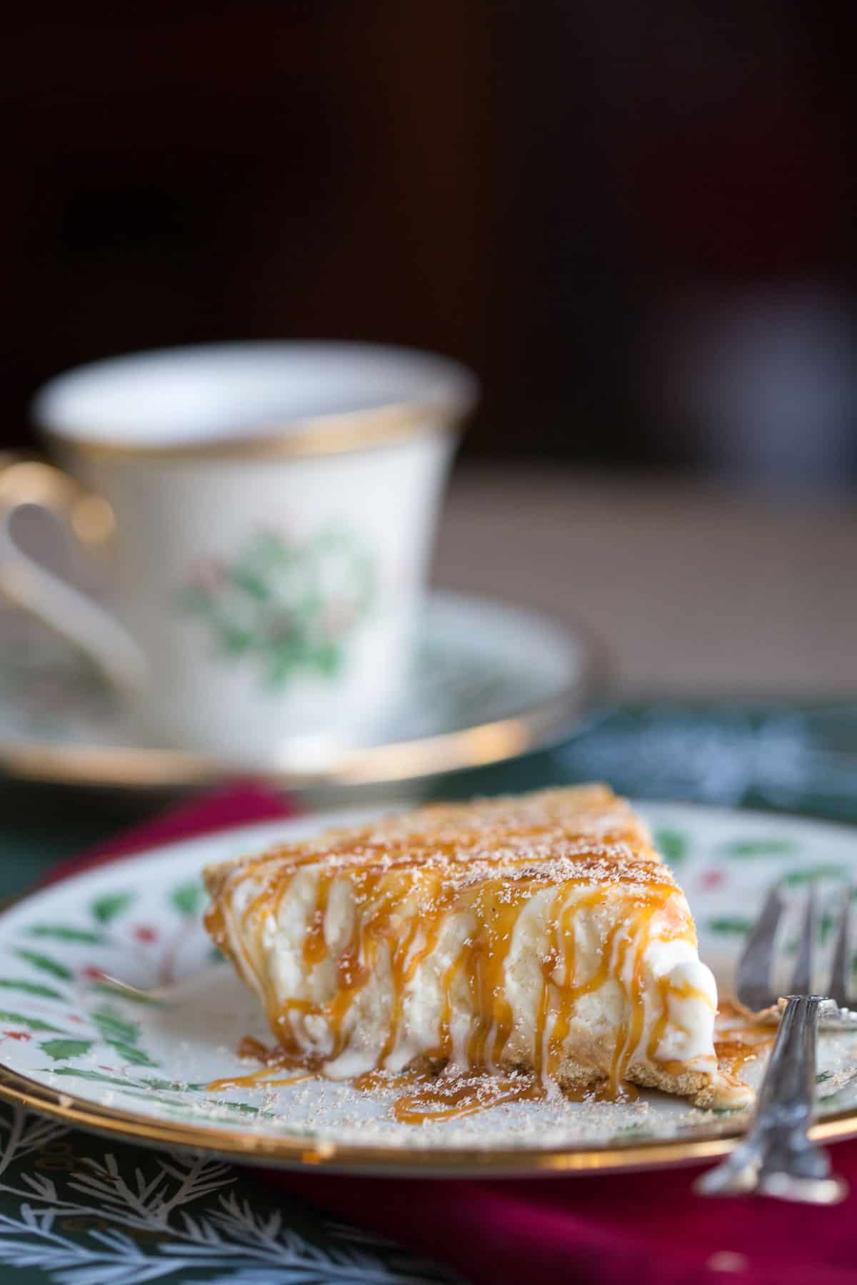 slice of eggnog pie drizzled with caramel on a china plate with red and green holly.