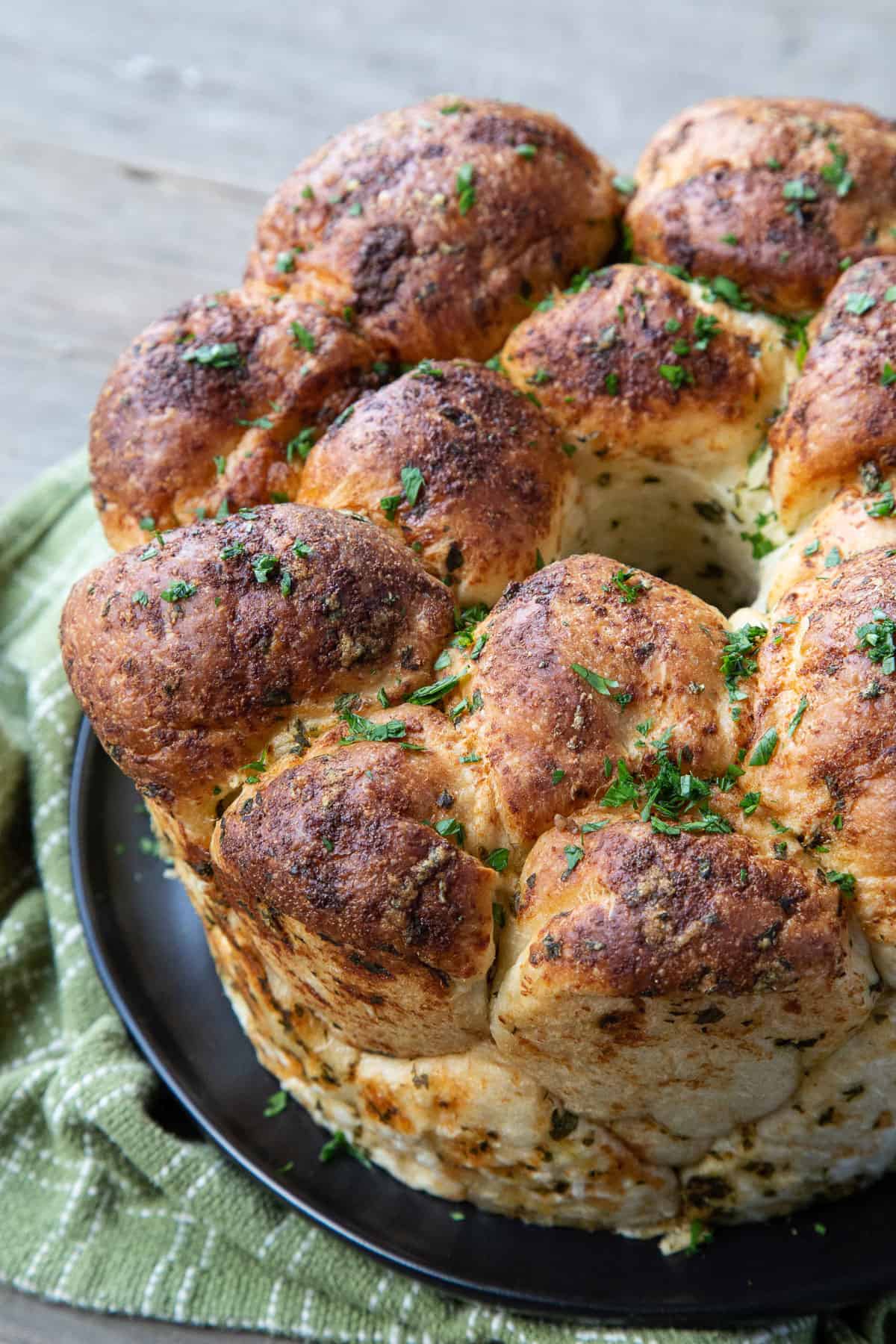 pull apart garlic bread on a black plate.