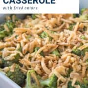 broccoli casserole topped with fried onions in a gray casserole dish.