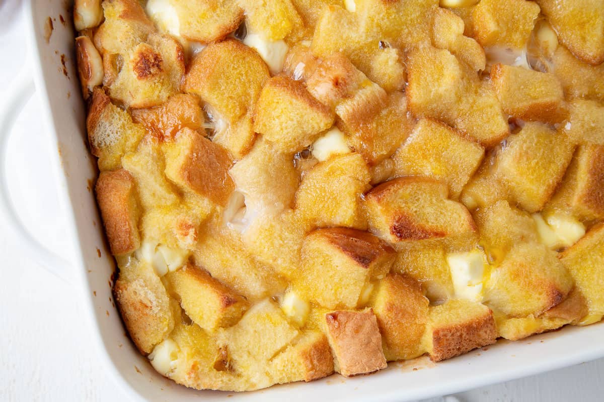 baked stuffed french toast casserole in a white casserole dish with handles.