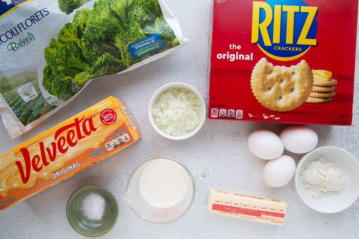 velveeta, ritz crackers, broccoli, and other ingredients on a white table.