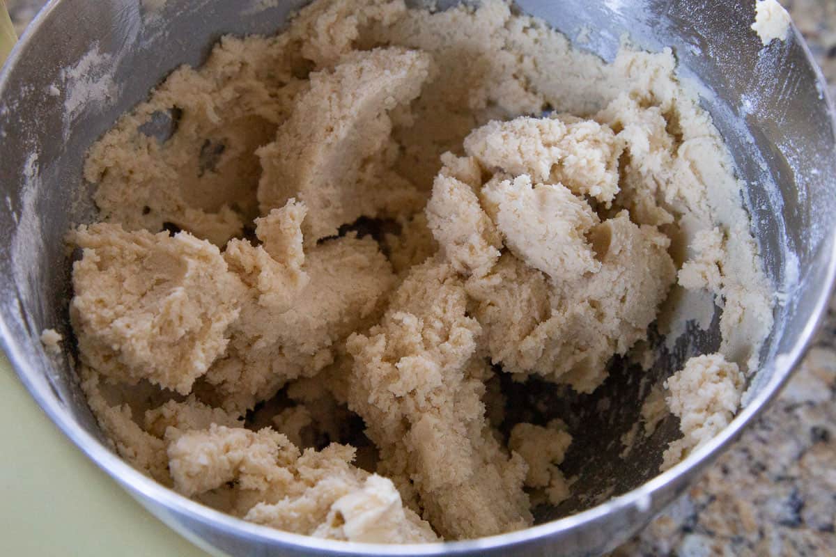 cookie dough in a metal bowl of a stand mixer.