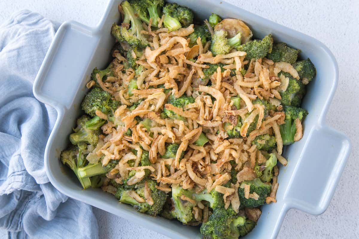broccoli casserole with fried onions in a gray square casserole dish.