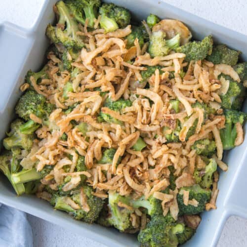 broccoli casserole with fried onions in a gray square casserole dish.