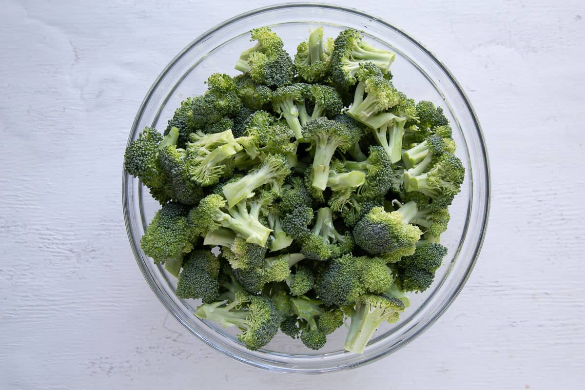 fresh broccoli florets in a glass bowl.