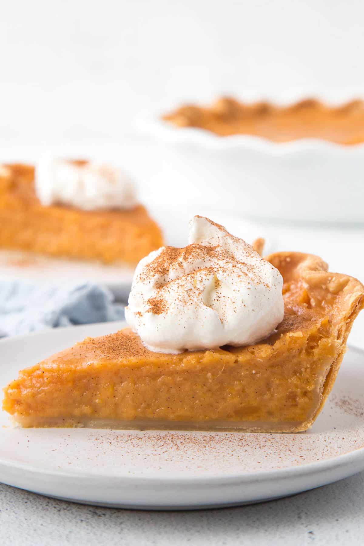 slice of old fashioned sweet potato pie topped with whipped cream.