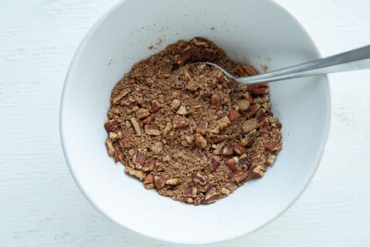 pecans and brown sugar in a small white bowl.