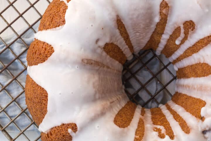bundt cake topped with a powdered sugar glaze on a wire rack.