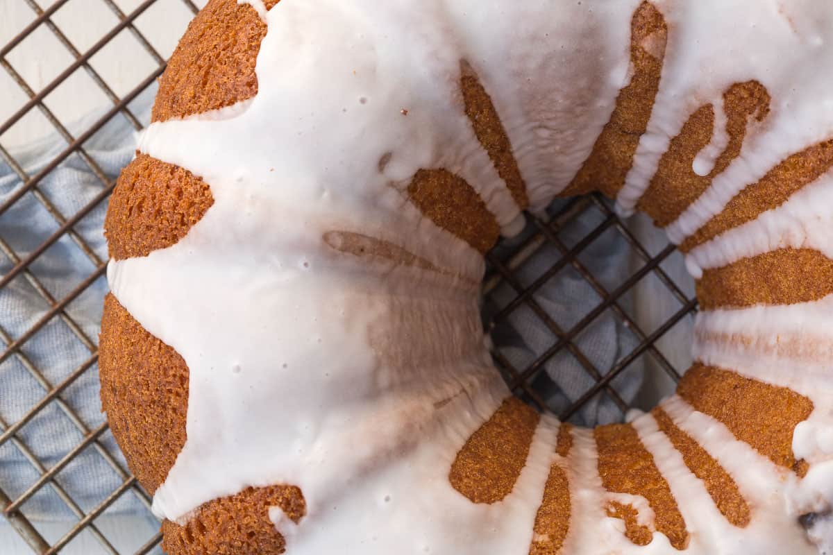 bundt cake topped with a powdered sugar glaze on a wire rack.