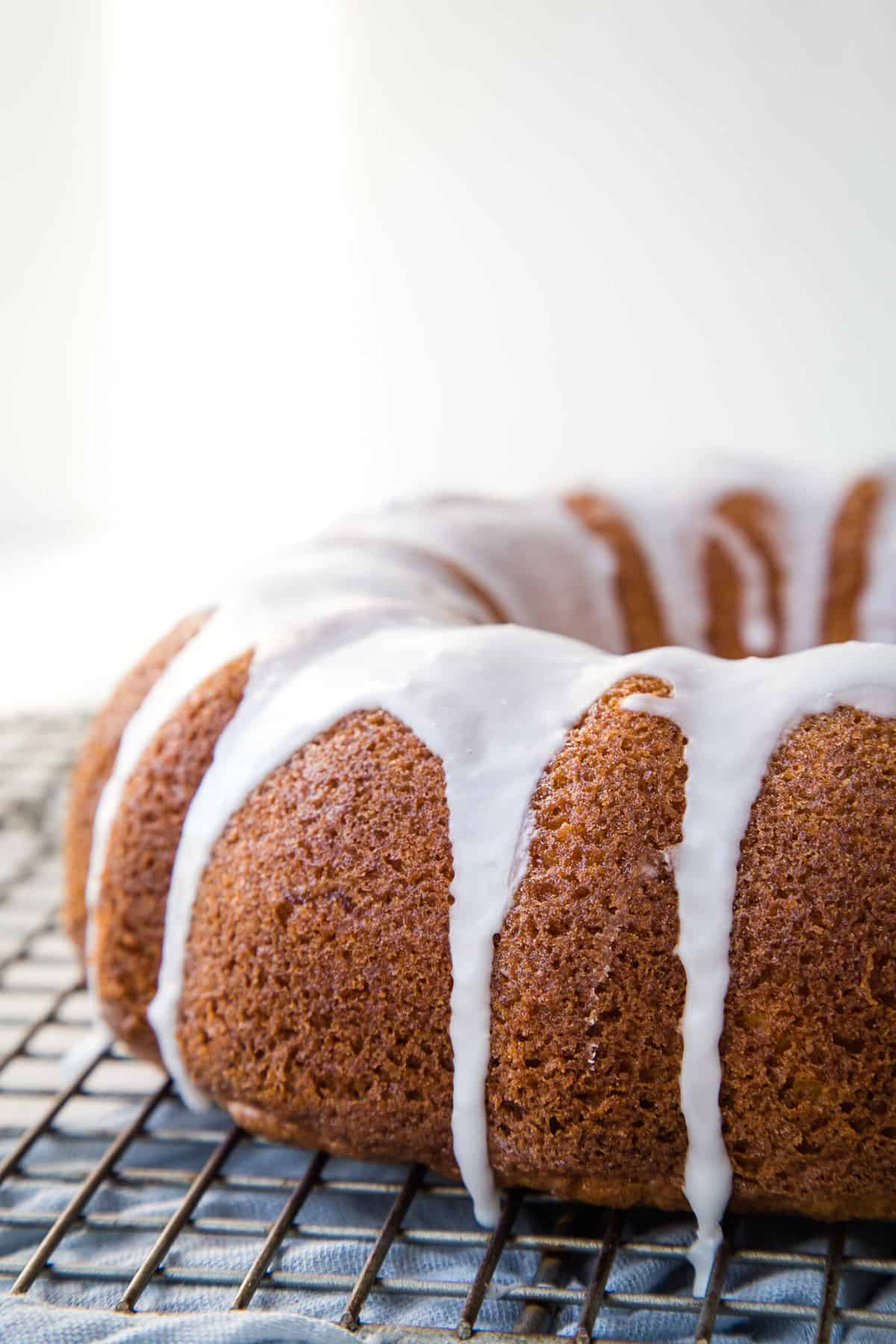 sock it to me bundt cake on a wire rack, topped with a white glaze dripping down the sides.