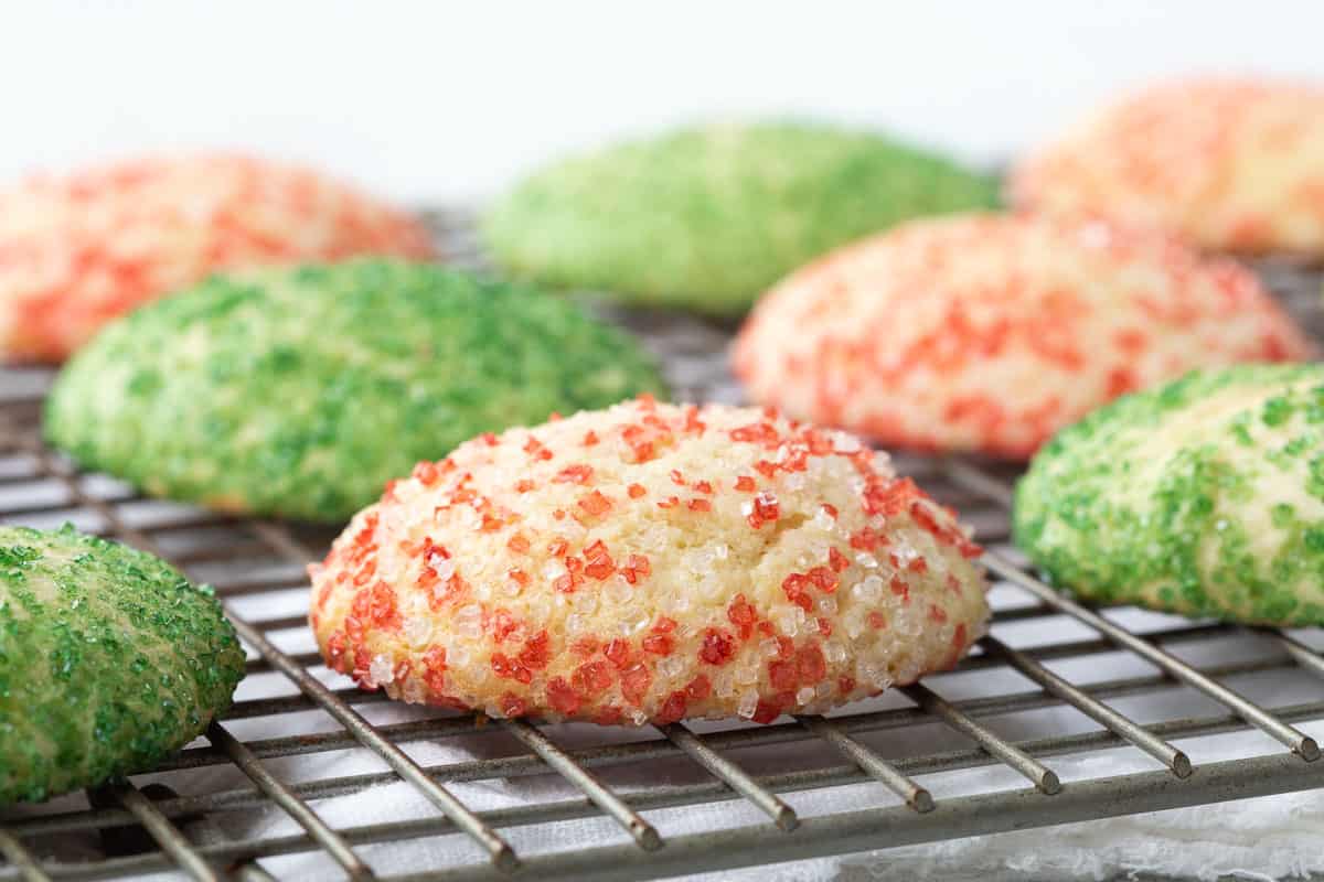 sour cream cookies covered in red and green sprinkles on a wire rack.