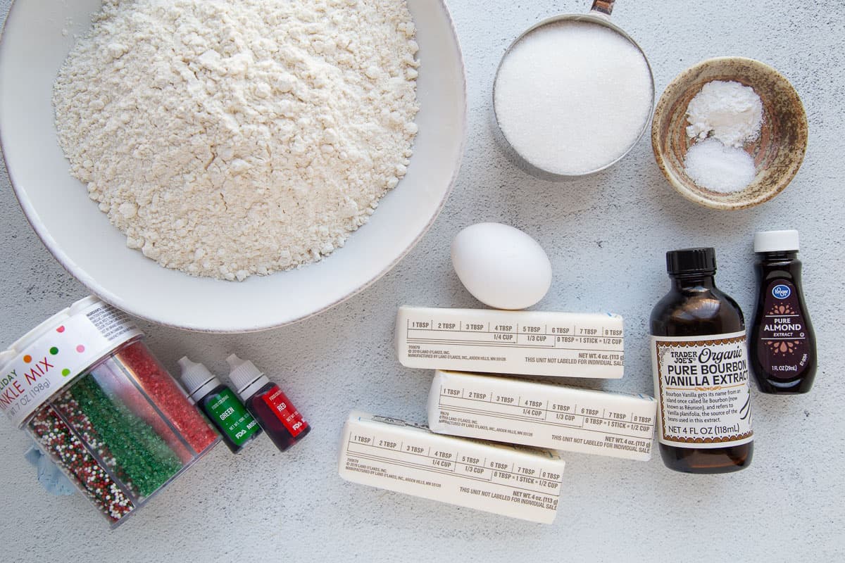 flour, butter, vanilla, sugar, and other baking ingredients on a white table.